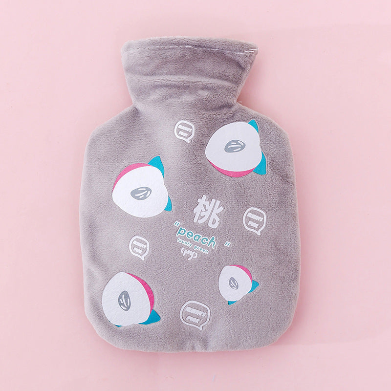 Bouillotte peluche grise à motif pêche, vue de face sur fond rose, col en peluche replié
