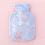 Bouillotte peluche bleue à motif pastèque, posée à plat sur fond rose, vue de face