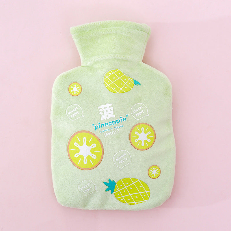 Bouillotte peluche verte à motif ananas, vue de face à plat sur fond rose poudré