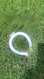 Tour de cou rafraîchissant PCM blanc posé sur l'herbe, forme d'anneau ouvert